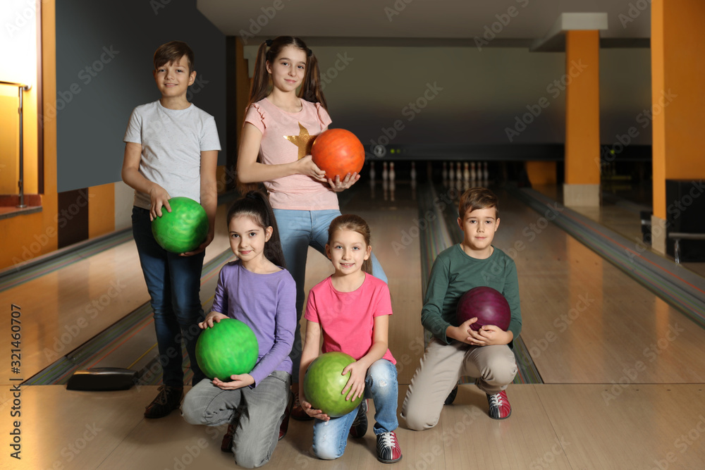Fototapeta premium Happy children with balls in bowling club