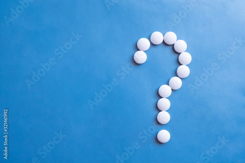 Question mark white pills on blue background. Medicine science. Cure concept. Question mark icon. Medicine pill.