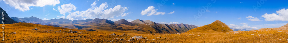 Panoramic view on mountains with mountain lake and blue sky. Beautiful alpine landscape. Rural scenery. Panoramic view on mountains with mountain lake and blue sky. Beautiful alpine landscape. Rural scenery.