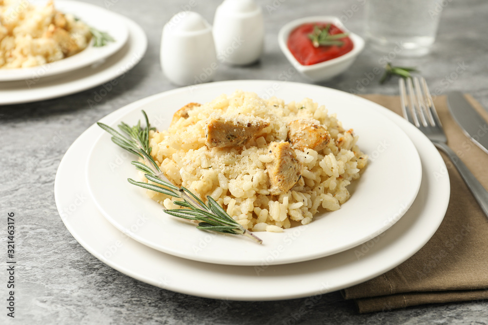 Delicious chicken risotto served on grey table