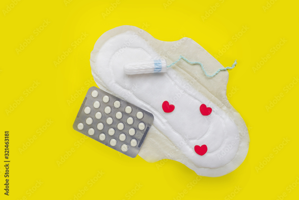 Sanitary napkins, tampons, in the yellow background. The concept of
