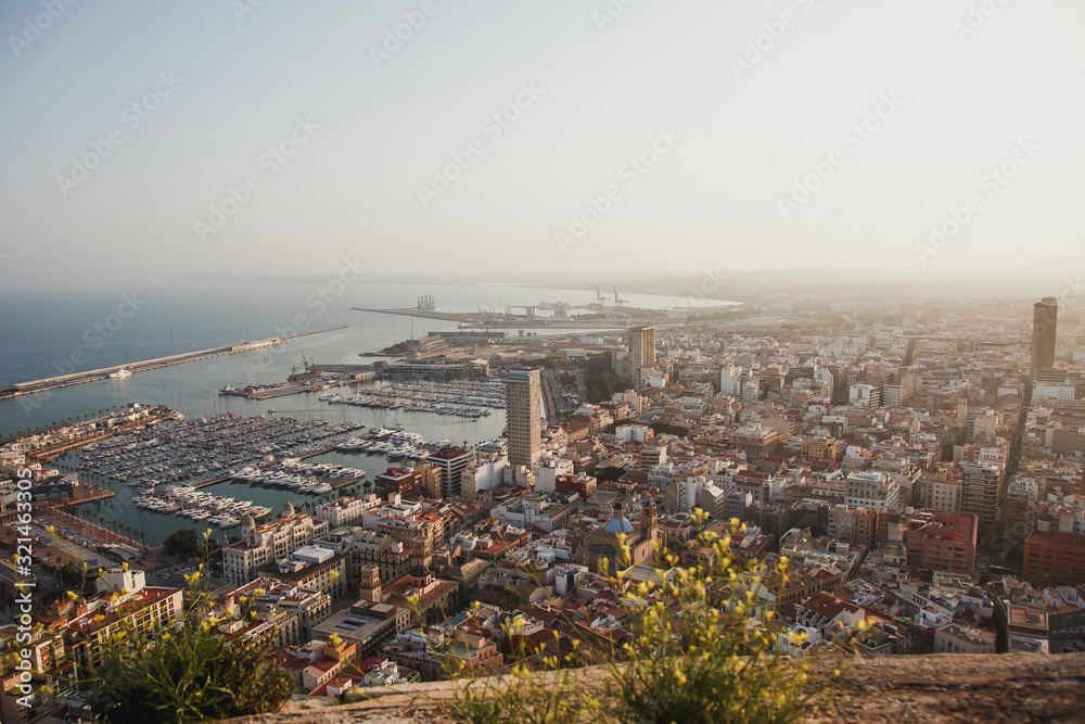 Alicante city and port panorama in haze at sunset in September