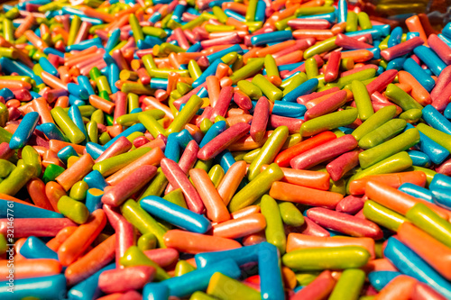 Abstract multicolored background made of many colorful sweet sticks of chewing sweets in icing. A tasty and healthy delicacy made from gelled fruit juice.