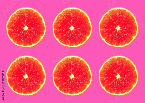  Slices of juicy orange mandarin on a pink background.