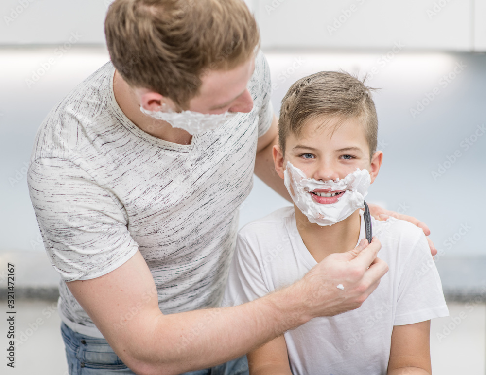 Happy family at home. Father and son have fun while shaving