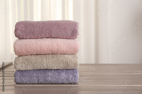 Photos Stack of fresh towels on wooden table in bathroom. Space for text