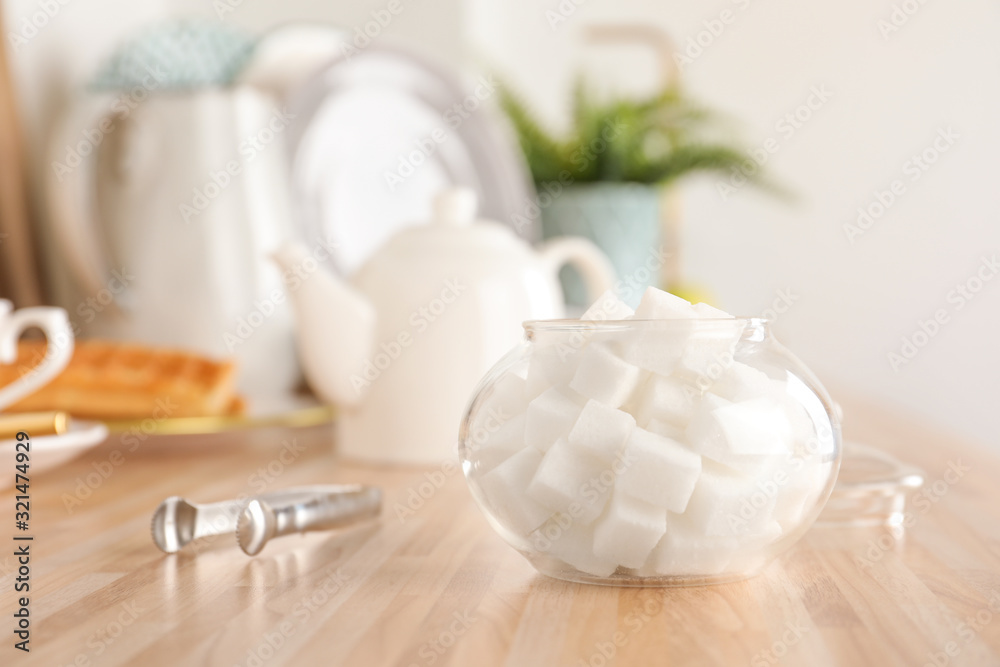 Glass bowl with white sugar cubes on wooden table Glass bowl with white sugar cubes on wooden table