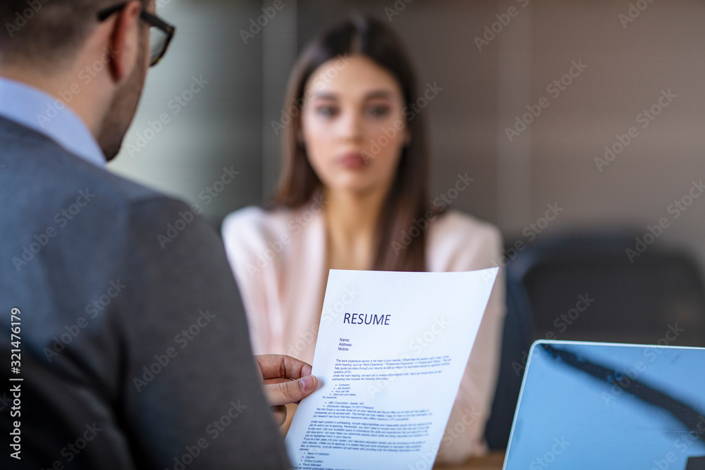 Job interview in office, focus on resume, close up. Perfect performance at job interview concept. Close up view over the shoulder at long sheet of paper with resume - obrazy, fototapety, plakaty 