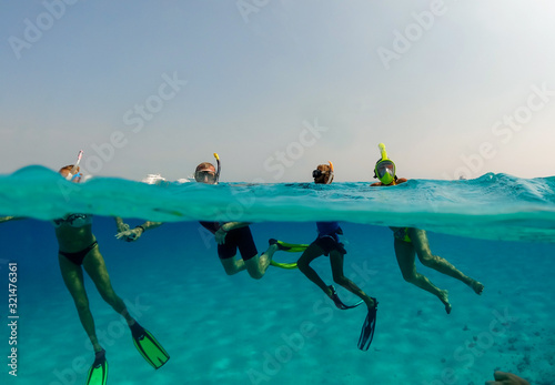 Group of tourists in the open ocean snorkeling reef excursion, Underwater split shot photos