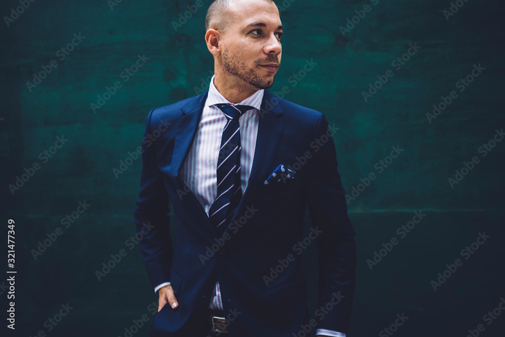 Elegant entrepreneur standing in street and looking away Elegant entrepreneur standing in street and looking away