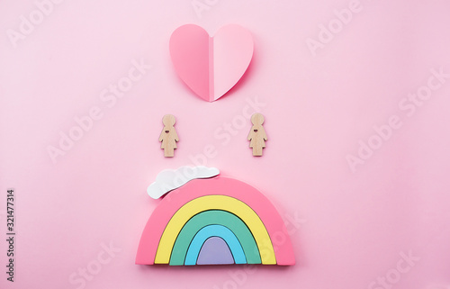  Den' svyatogo Valentina. Raduga i dve igrushechnykh zhenshchiny lesbiyanki na myagkom rozovom fone. Kontseptsiya gey-parada, soobshchestva LGBT, usynovleniya i prav cheloveka. photo