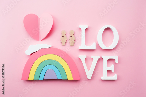  Den' svyatogo Valentina. Raduga i dve igrushechnykh zhenshchiny lesbiyanki na myagkom rozovom fone. Kontseptsiya gey-parada, soobshchestva LGBT, usynovleniya i prav cheloveka. photo