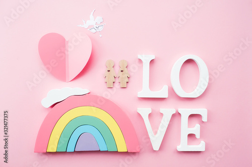  Den' svyatogo Valentina. Raduga i dve igrushechnykh zhenshchiny lesbiyanki na myagkom rozovom fone. Kontseptsiya gey-parada, soobshchestva LGBT, usynovleniya i prav cheloveka. photo