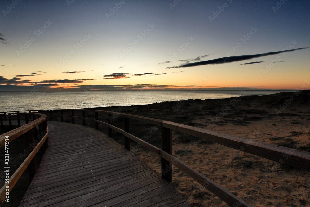 Wooden walkway to the beach at sunrise in Alicante, Spain