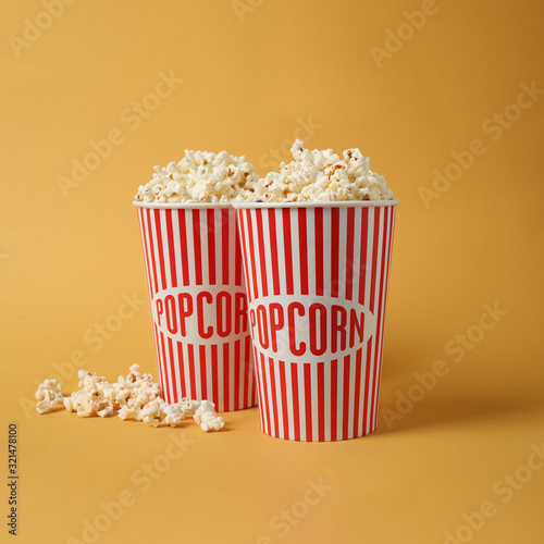 Delicious popcorn in paper cups on yellow background © New Africa