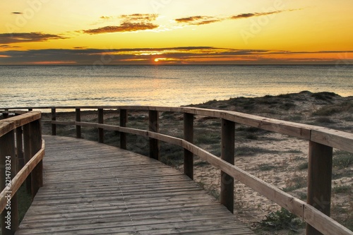 Fototapeta Naklejka Na Ścianę i Meble -  Wooden walkway to the beach at sunrise in Alicante, Spain