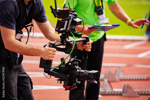 Close-up of videographer shooting with camera standing on the track