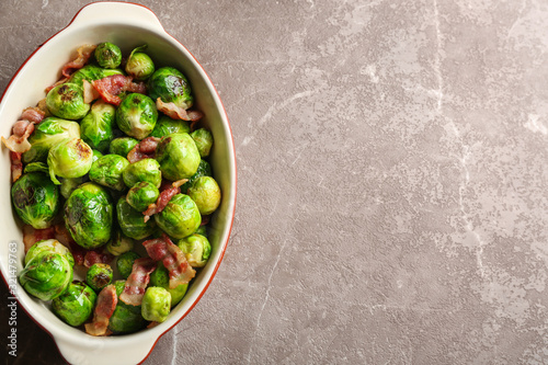Delicious Brussels sprouts with bacon on marble table, top view. Space for text © New Africa