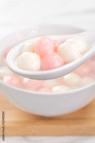 Tang yuan, tangyuan, delicious red and white rice dumpling balls in a small bowl. Asian traditional festive food for Chinese Winter Solstice Festival, close up.