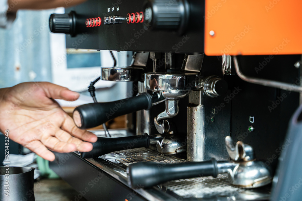 Prepares espresso machine brewing a coffee in coffee shop