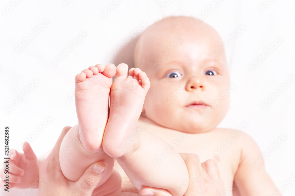 Mother holding logs of infant little baby playing with him view from above Mother holding logs of infant little baby playing with him view from above