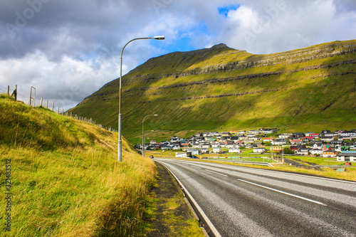 Road in a mountain valley near the village in good wheather. Location - Faroe islands