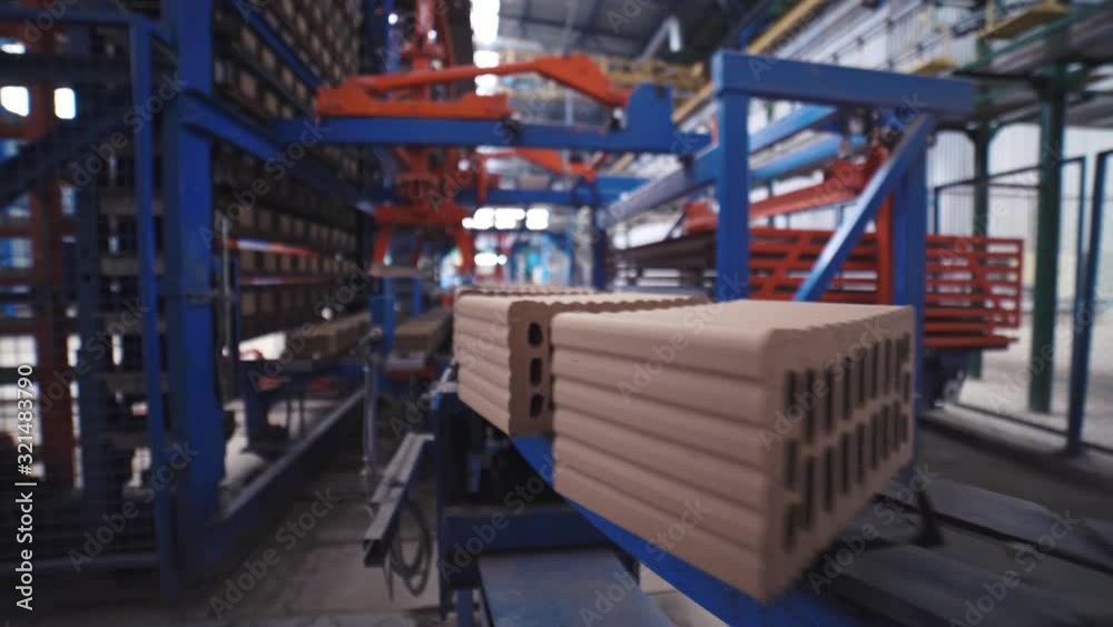 Grey bricks are moving on a manufacturing line on the fully automated factory Grey bricks are moving on a manufacturing line on the fully automated factory