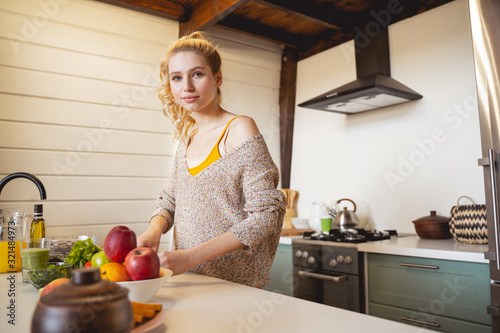 Charming young blonde girl cooking healthy dinner