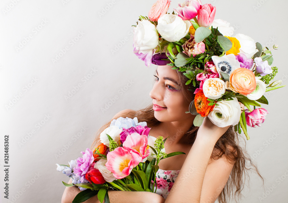 Beautiful young smiling model with bright flowers on her head Beautiful young smiling model with bright flowers on her head
