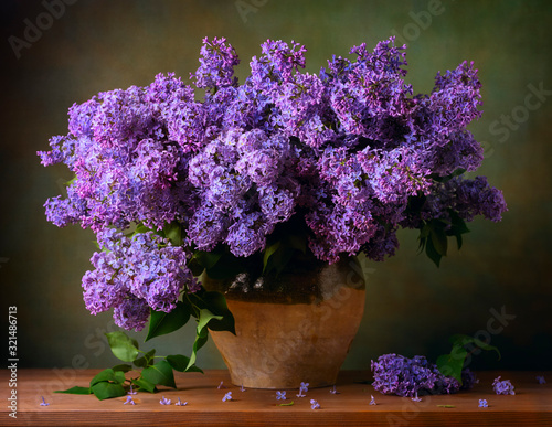 Stampa su tela Still life with a bouquet of lilacs on the table