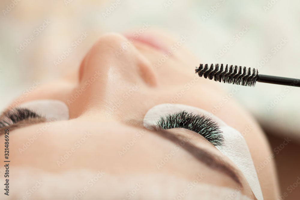 Eyelash extension procedure in beauty salon close up