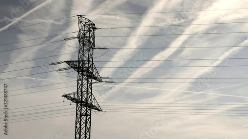 High voltage pylon, sky in background. Metal pole voltage, industrial building. Power line pylon with safety lock. Nuclear facilities power