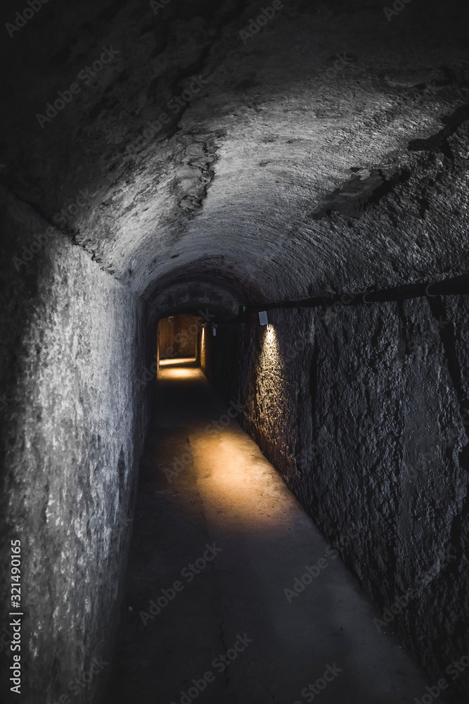 a tunnel carved into the rock that leads to the ruins of an ancient Roman city