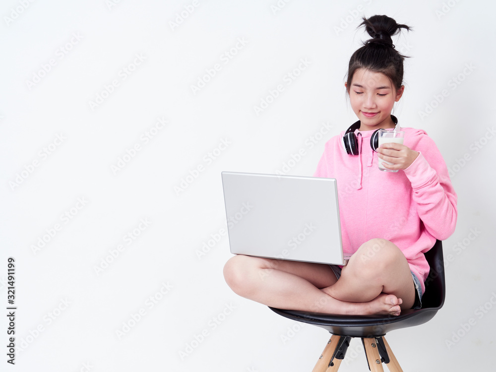 Cheerful girl using laptop sitting on chair. Cheerful girl using laptop sitting on chair.