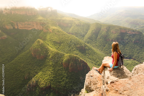 female hiking tourist sitting on mountains and enjoying the view photo