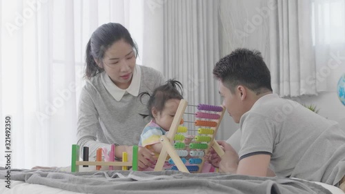 Happy family times , Asian parents playing ant teaching daughter at home together Happily.
