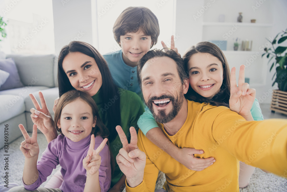 Obraz premium Self-portrait of nice attractive big full cheerful cheery glad family pre-teen kids mom dad having fun showing v-sign at cozy comfortable light white interior style house apartment