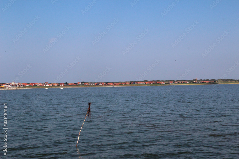 blick auf die nordsee mit gebäuden am horizont auf der  nordsee insel juist in deutschland