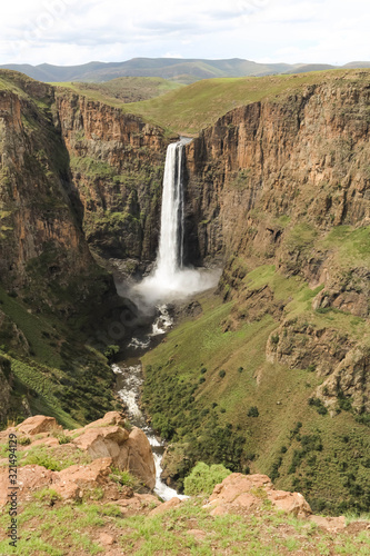 portrait shot of stunning waterfall running down a steap canyon