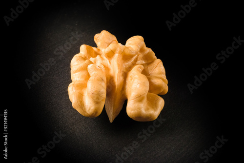 Still life with a walnut peeled on black background.