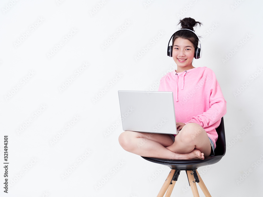 Cheerful girl using laptop sitting on chair. Cheerful girl using laptop sitting on chair.