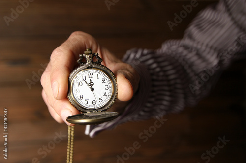 a pocket watch in the hands of a man