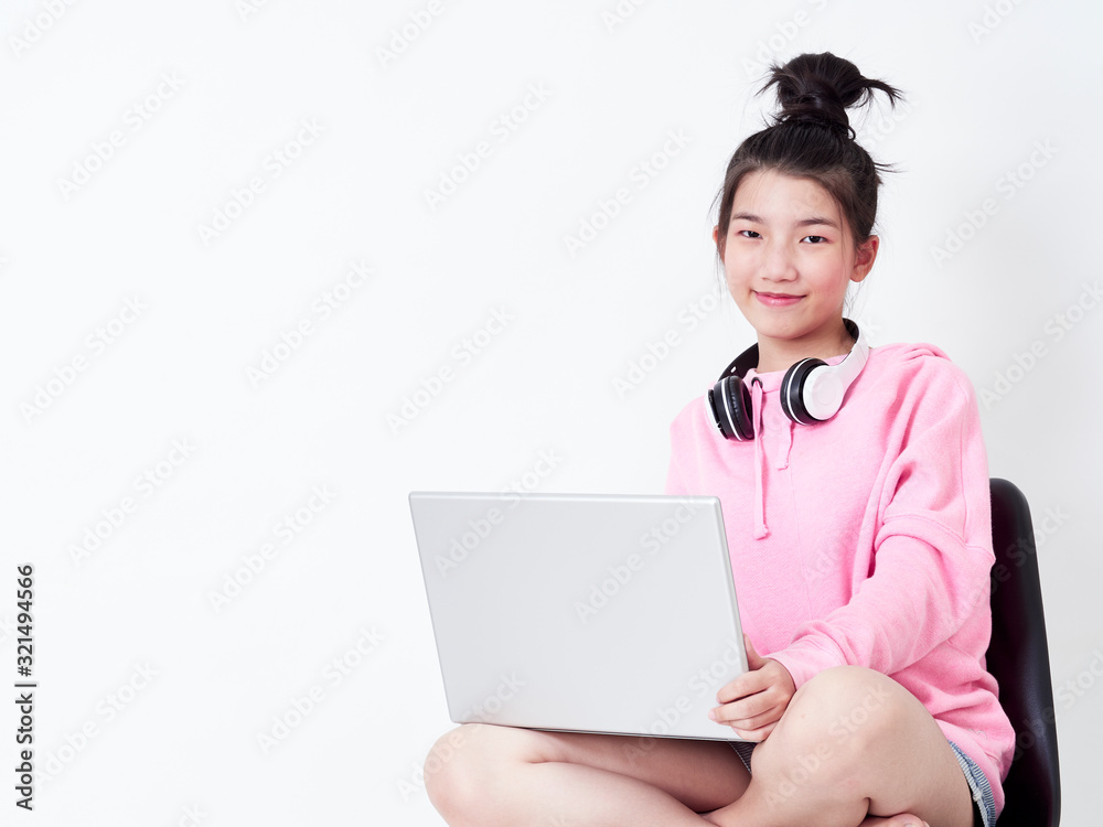 Cheerful girl using laptop sitting on chair. Cheerful girl using laptop sitting on chair.