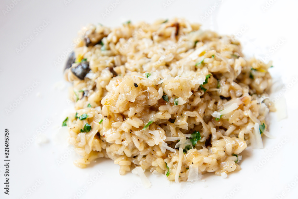 Delicious Italian vegetarian risotto cooked with mushrooms and onions served in white plate. Delicious Italian vegetarian risotto cooked with mushrooms and onions served in white plate.