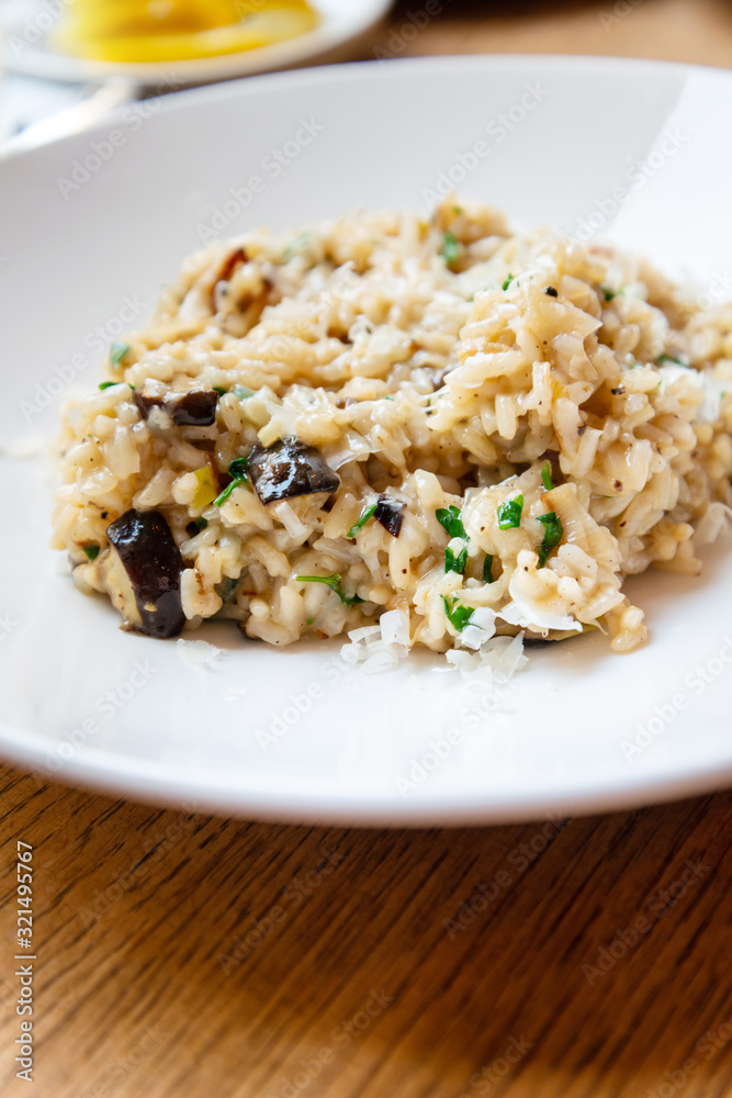 Delicious Italian vegetarian risotto cooked with mushrooms and onions served in white plate. Delicious Italian vegetarian risotto cooked with mushrooms and onions served in white plate.