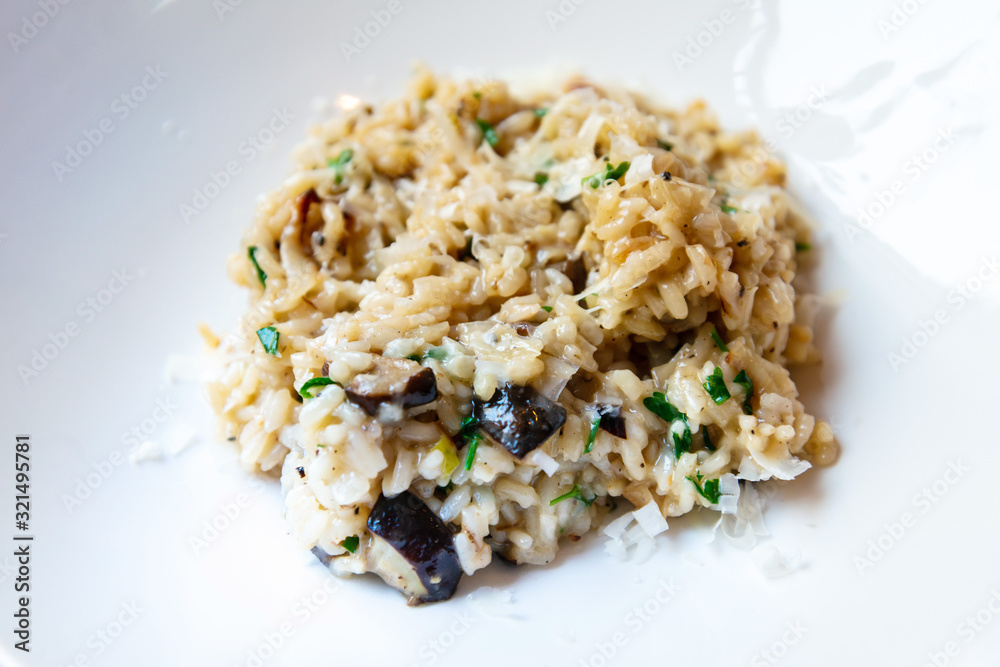 Delicious Italian vegetarian risotto cooked with mushrooms and onions served in white plate. Delicious Italian vegetarian risotto cooked with mushrooms and onions served in white plate.