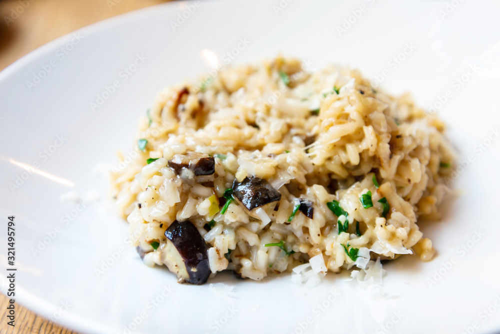 Delicious Italian vegetarian risotto cooked with mushrooms and onions served in white plate. Delicious Italian vegetarian risotto cooked with mushrooms and onions served in white plate.