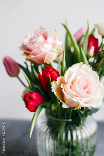 Fototapeta Naklejka Na Ścianę i Meble -  Spring bouquet in transparent glass vase. Roses, tulips and lisianthus.