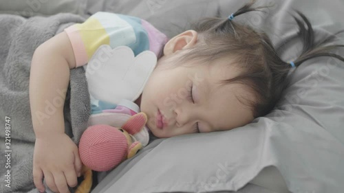 A cute little Asian baby is sleeping happily. With the mother looking after closely Happily.
