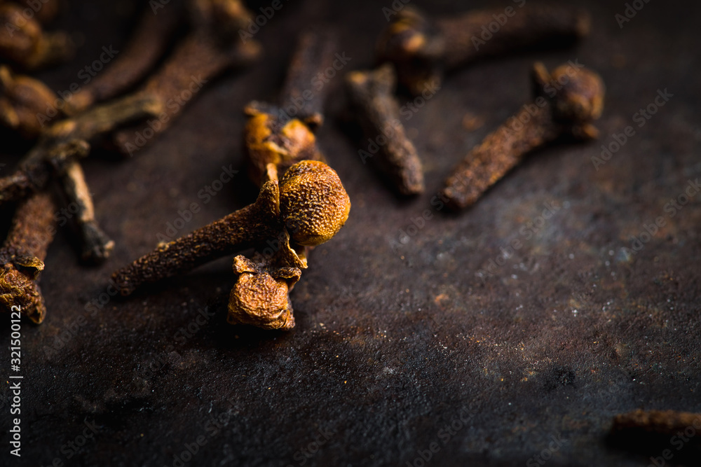 Dry cloves spices on the dark rustic background. Selective focus. shallow depth of field. Dry cloves spices on the dark rustic background. Selective focus. shallow depth of field.